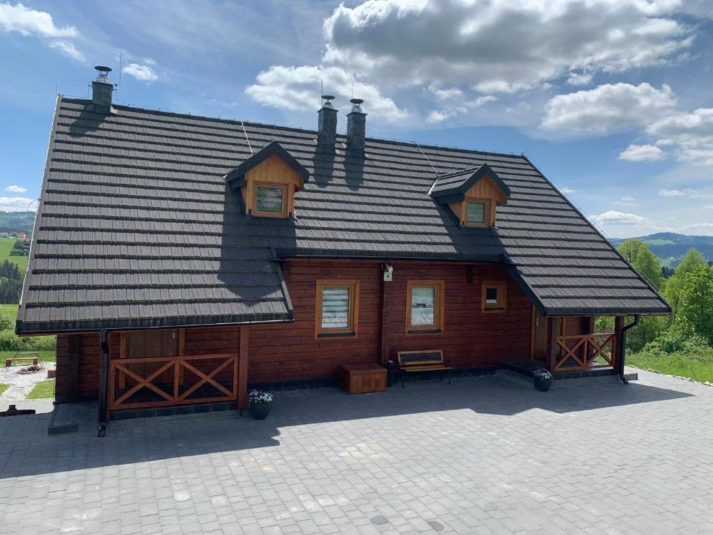 a large wooden cabin with a gambrel roof at Widokowa Chata Jaworzynka in Istebna