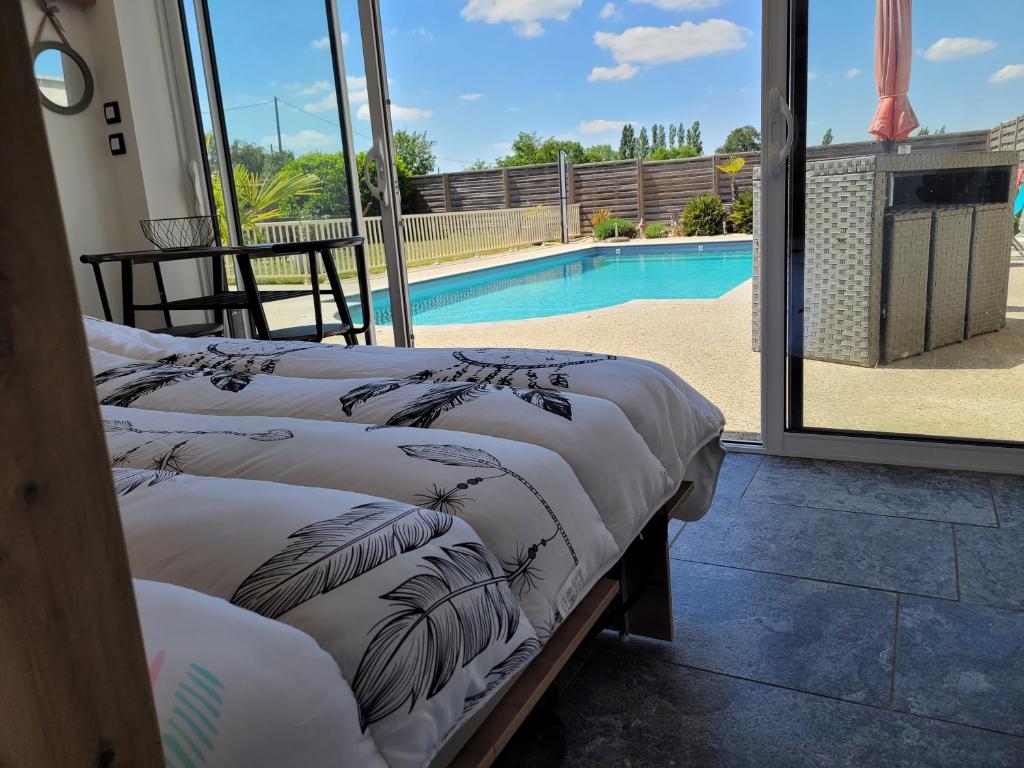 La pool house في Saint-Aubin-du-Plain: سريرين في غرفة مع مسبح