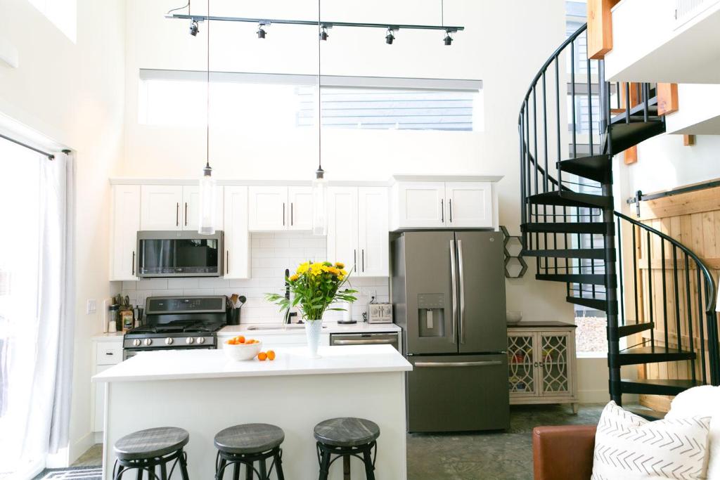 a kitchen with white cabinets and a green refrigerator at LUX Modern Chalet, Pool & Hot Tub, 10 Mins to the Mountain & Incredible Views in Whitefish