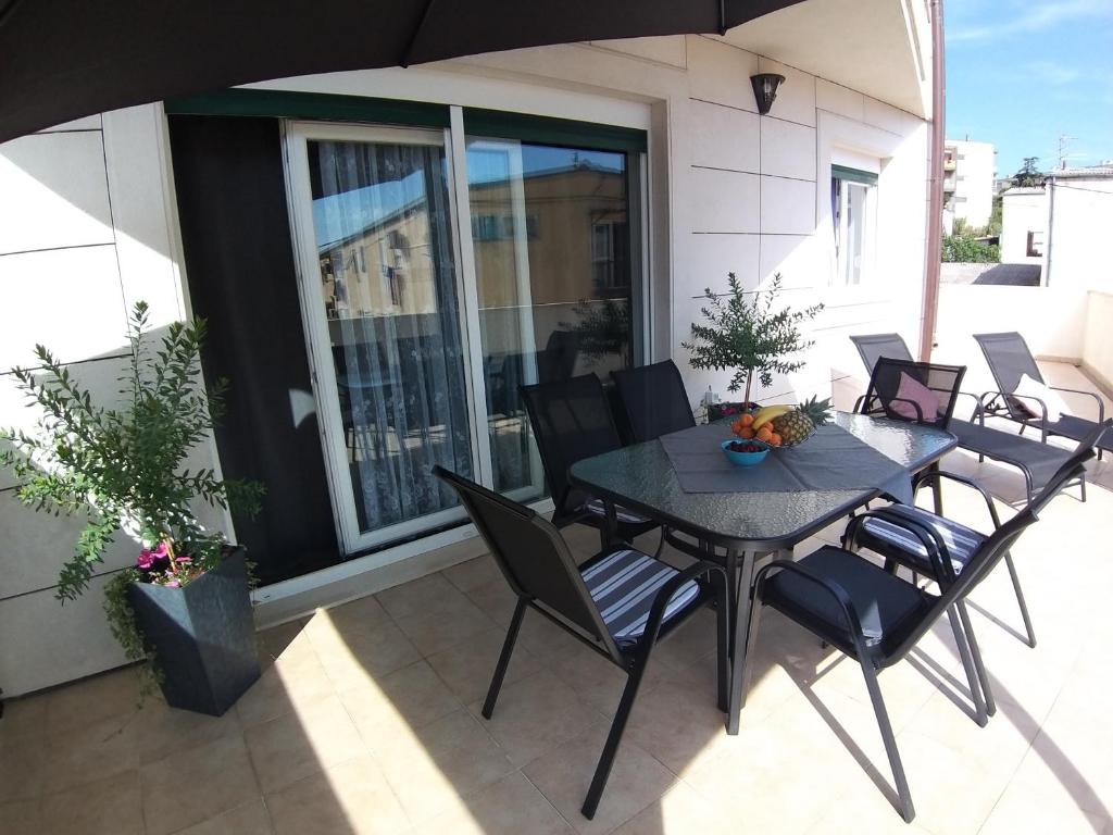 un tavolo e sedie su un patio con ombrellone di 3 bedroom apartment with terrace and free parking a Spalato (Split)