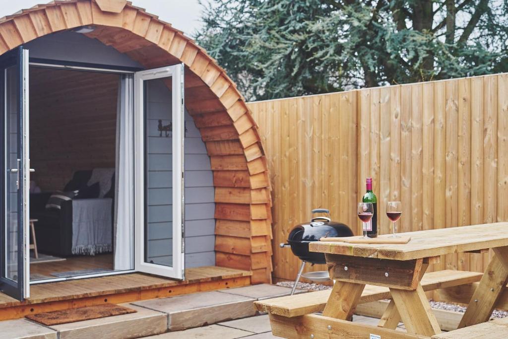 a patio with an arbor and a table with a bottle of wine at Hidden Orchard in Chester