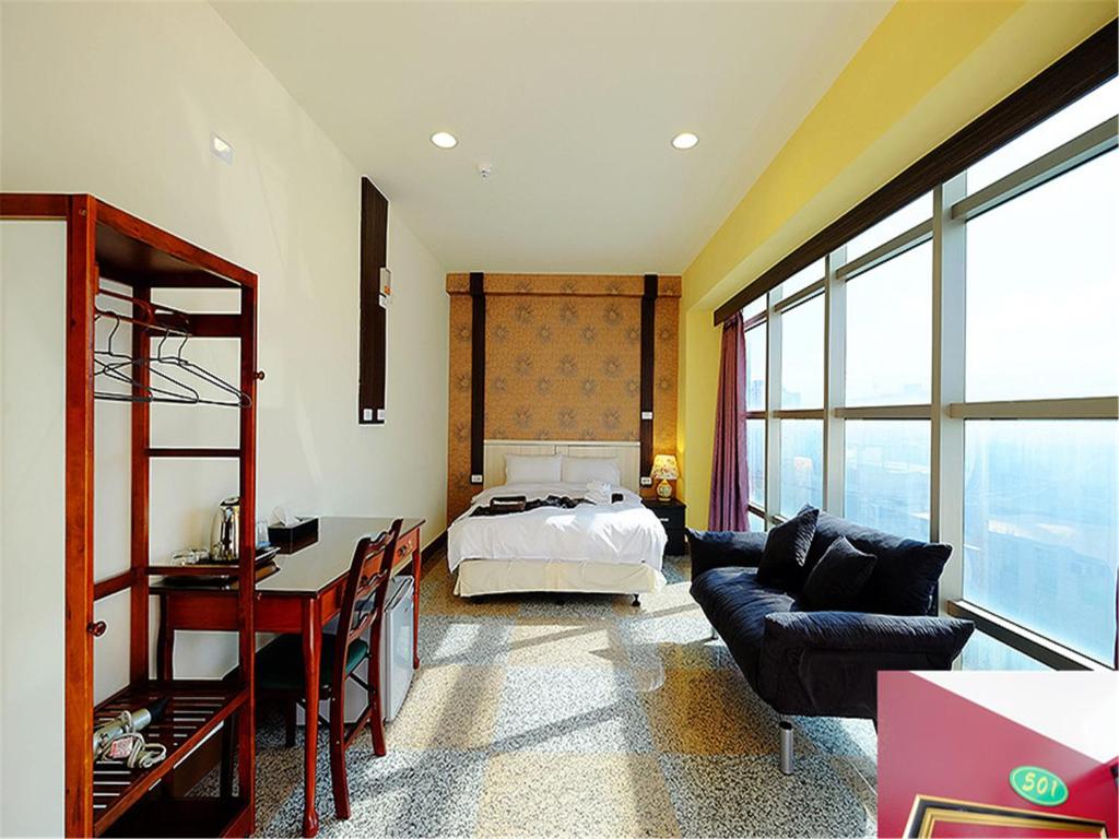 1 dormitorio con cama, escritorio y sofá en 台東市安慶67套房館歡迎短租長租 en Taitung