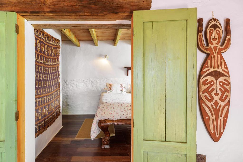 a bedroom with a bed and a surfboard on the wall at Lanzahost Finca Mojon in El Mojón