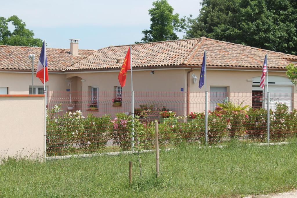 una casa con banderas delante de ella en B&B La Garona, en Saint-Nicolas-de-la-Grave