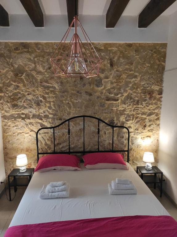 een slaapkamer met een groot bed met 2 roze kussens bij Il Ronco di Archimede in Siracusa