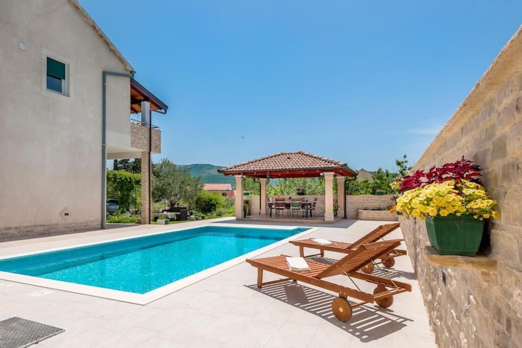 a villa with a swimming pool and a gazebo at APARTMENT AMELIA VRPOLJE in Vrpolje