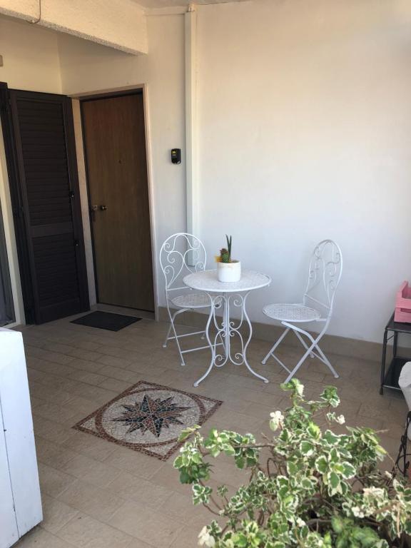 eine Terrasse mit einem Tisch, Stühlen und einer Tür in der Unterkunft Casa di Taty - Home resort in Policoro