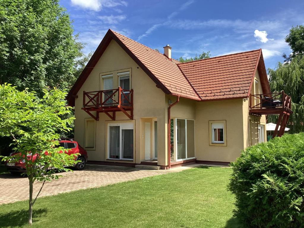 uma pequena casa com um telhado vermelho em Szigliget Strand mellet levő, csendes, kényelmes ház em Szigliget