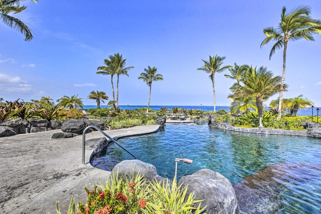 a pool at the beach with palm trees at Sun-Soaked Waikoloa Retreat with Private Lanai! in Waikoloa