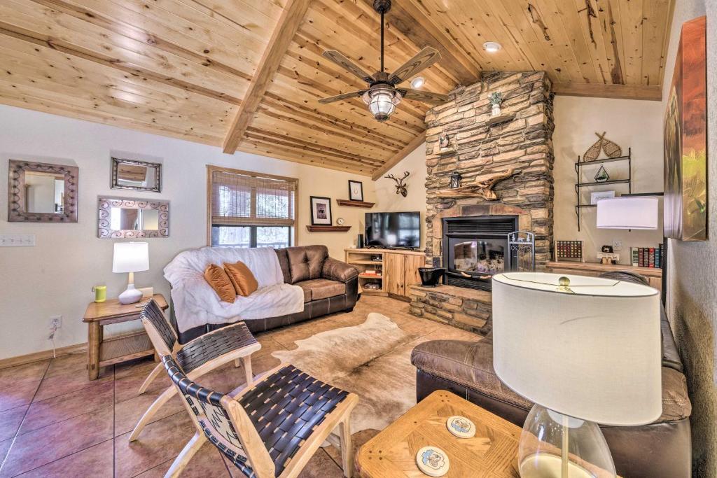 un soggiorno con divano e camino di Cozy Ruidoso Cabin Retreat with Private Hot Tub a Ruidoso