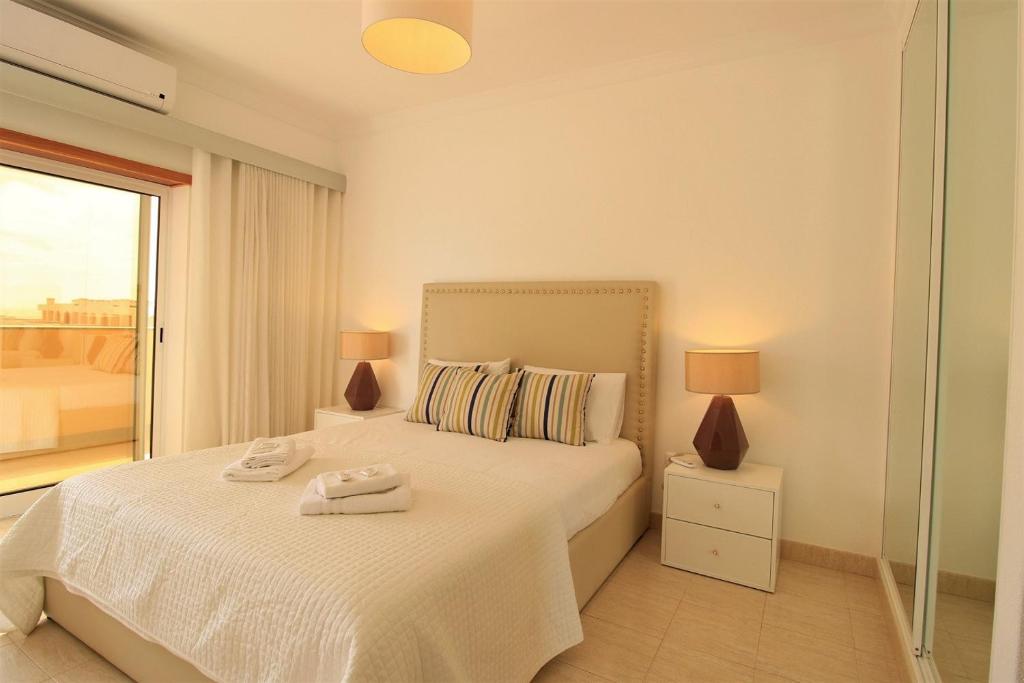 ein Schlafzimmer mit einem Bett mit zwei Handtüchern darauf in der Unterkunft Armação de Pêra Brightness With Pool by Homing in Armação de Pêra