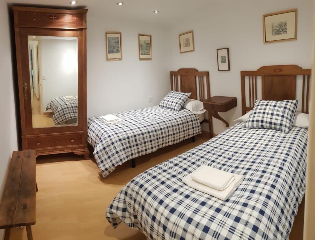 een kamer met 2 bedden en een spiegel bij EVA & TRAVEL - Cal Manco in Ulldemolins
