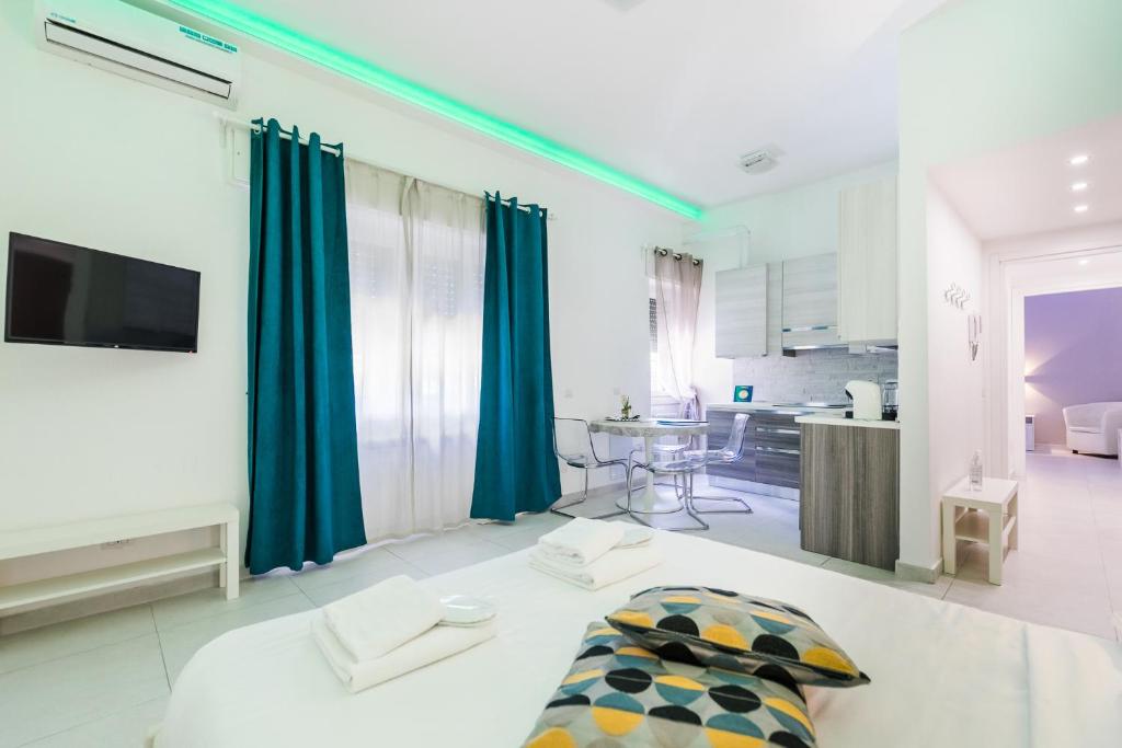 ein großes Wohnzimmer mit blauen Vorhängen und eine Küche in der Unterkunft Appartamento 21 in Mailand