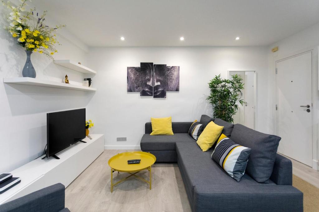 a living room with a couch and a tv at New apartment in the neighborhood of Amara. in Loyola