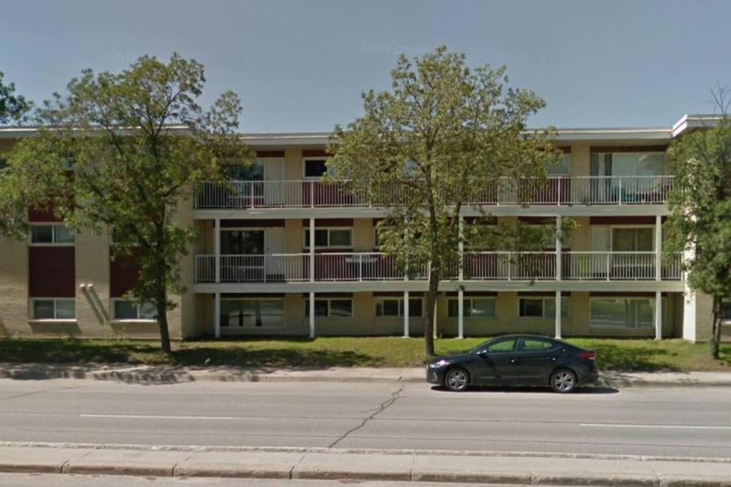 a car parked in a parking lot in front of a building at Chris Cozy Condo Lebay Regina in Regina