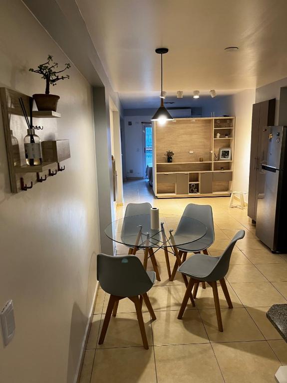 eine Küche und ein Esszimmer mit einem Glastisch und Stühlen in der Unterkunft Departamento en San Miguel de Tucumán in San Miguel de Tucumán
