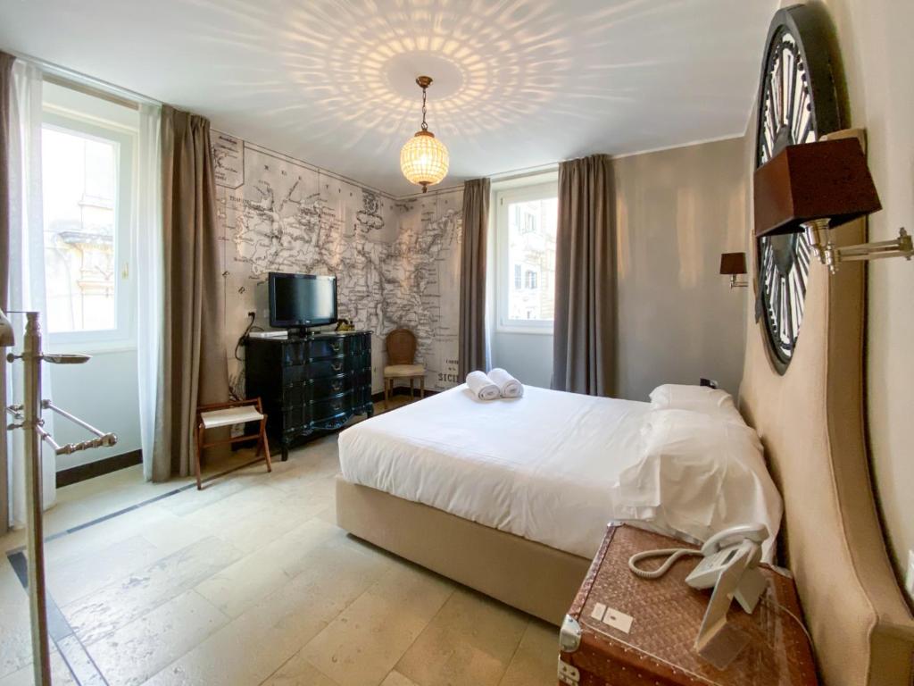 sypialnia z łóżkiem i zegarem na ścianie w obiekcie La Dépendance Hotel w mieście Noto