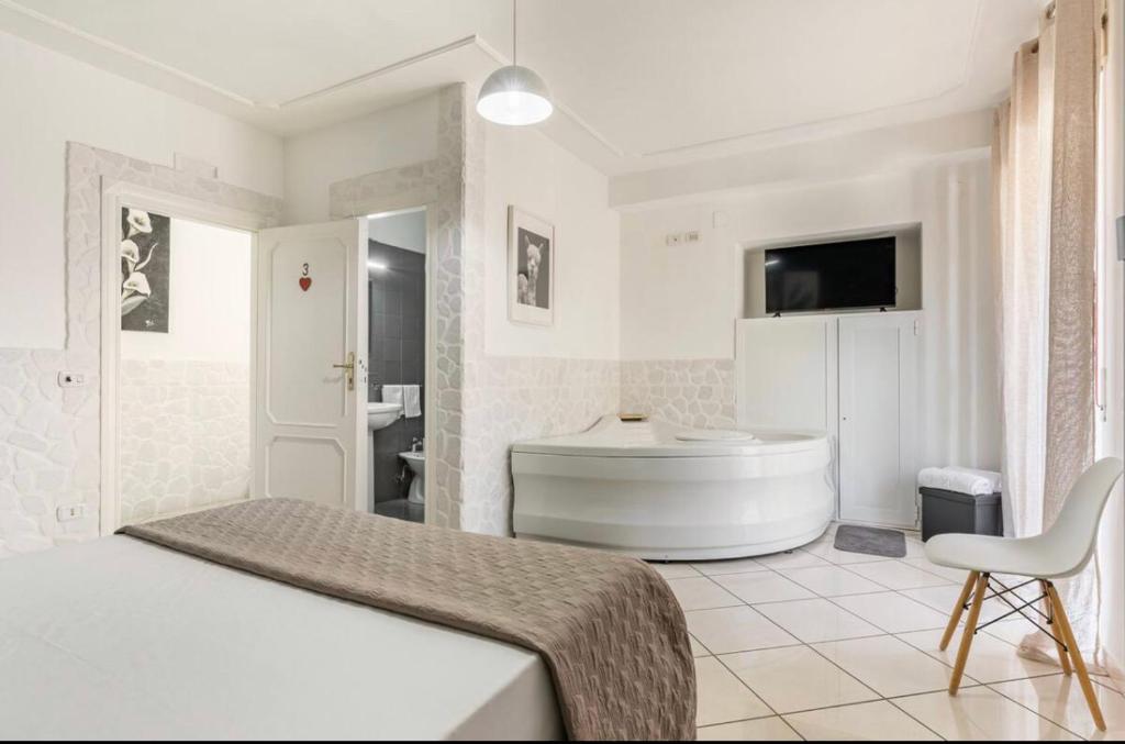 1 dormitorio con cama, bañera y baño en B&B Civico 8, en Pompeya