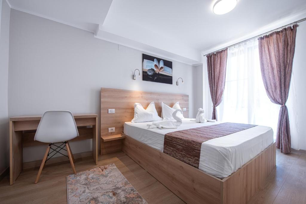 a bedroom with a bed and a desk and a chair at Polu-X in Vama Veche