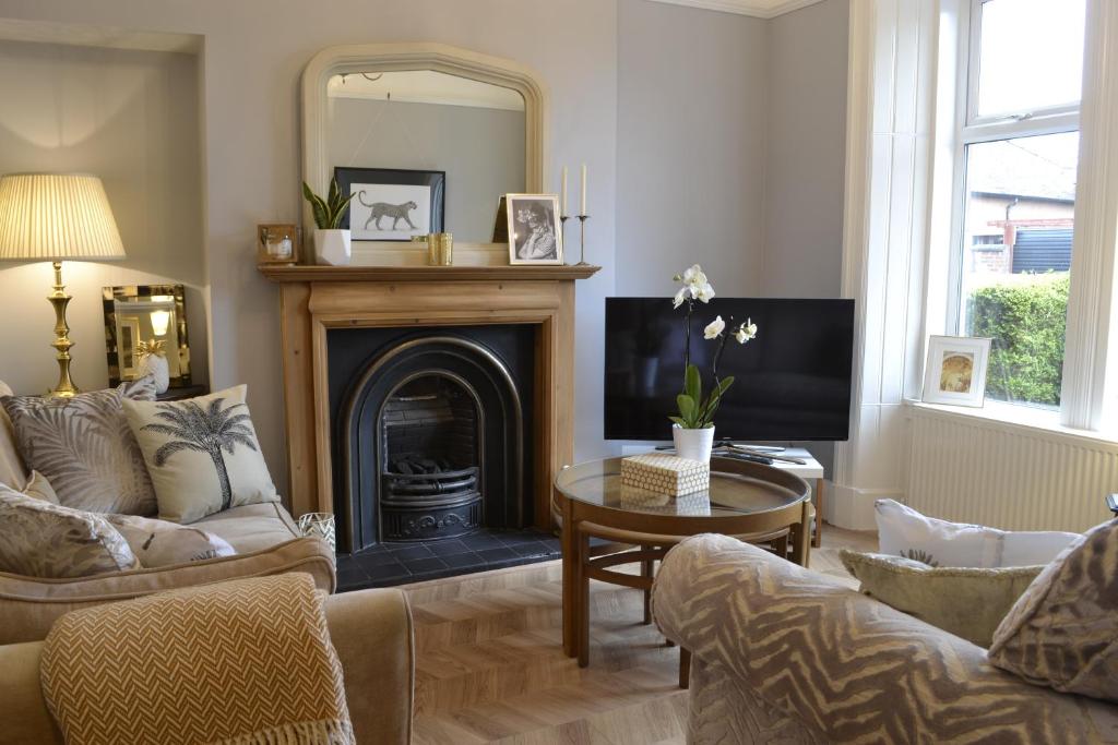 a living room with a fireplace and a mirror at Stunning Period Townhouse with Garden, Walking Distance to Town in Dumfries