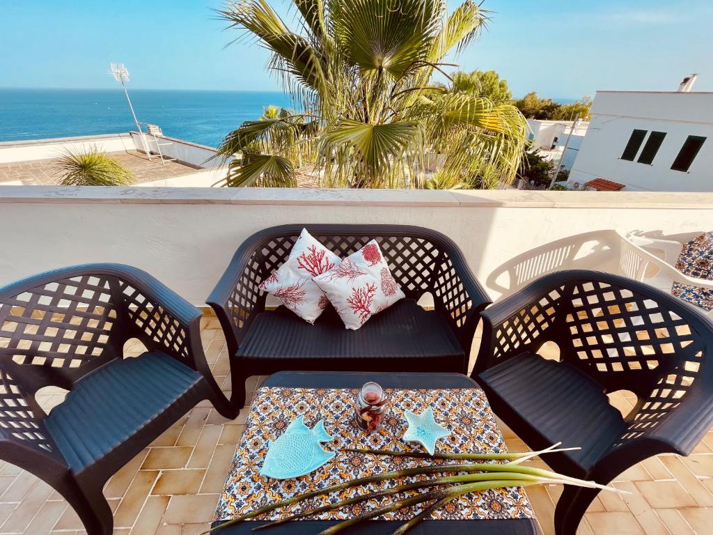 d'une chaise et d'une table avec des oreillers sur un balcon. dans l'établissement Villetta Claudia, à Castro di Lecce