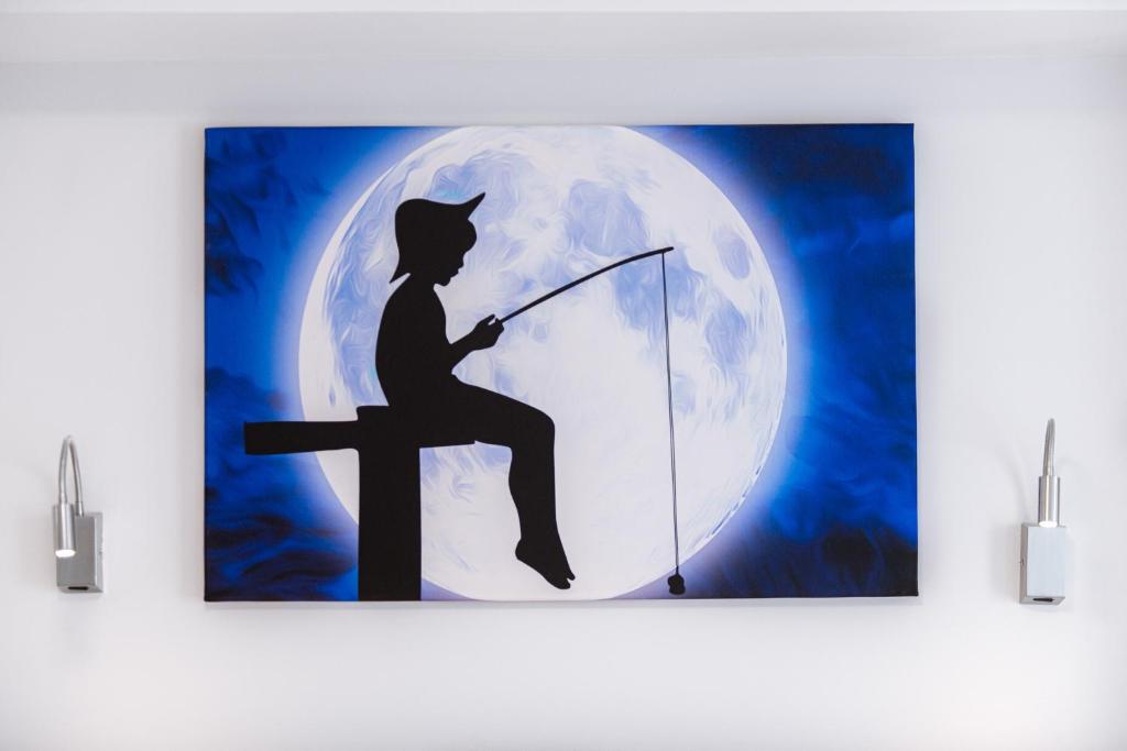 a painting of a boy fishing in front of a moon at Polu-X in Vama Veche