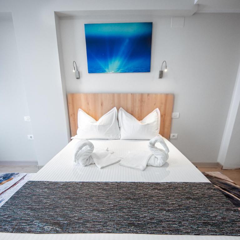a bedroom with a bed with white sheets and pillows at Polu-X in Vama Veche