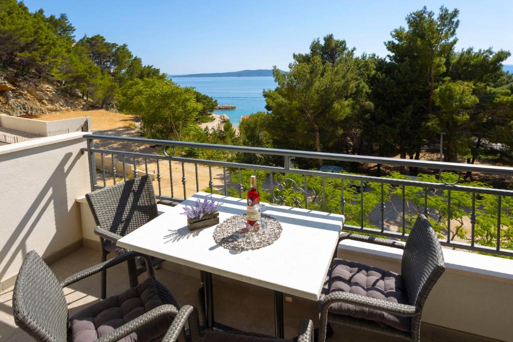 einen Balkon mit einem Tisch, Stühlen und Meerblick in der Unterkunft Apartments Vicin in Brela