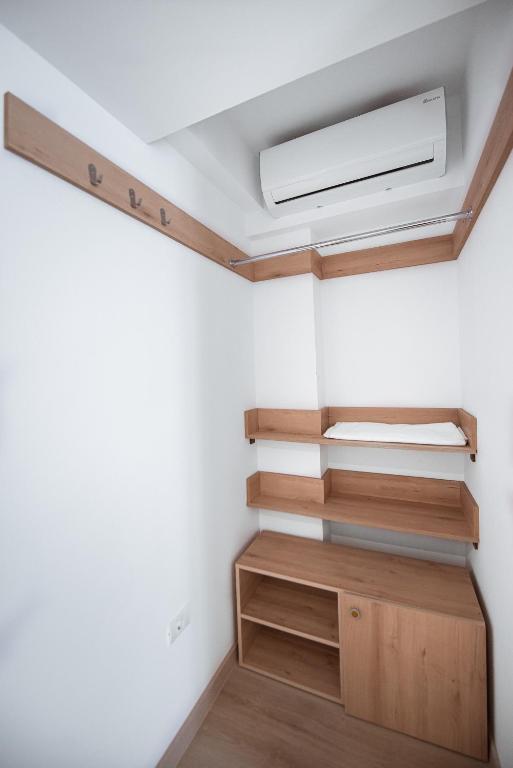 a room with white walls and wooden shelves at Polu-X in Vama Veche