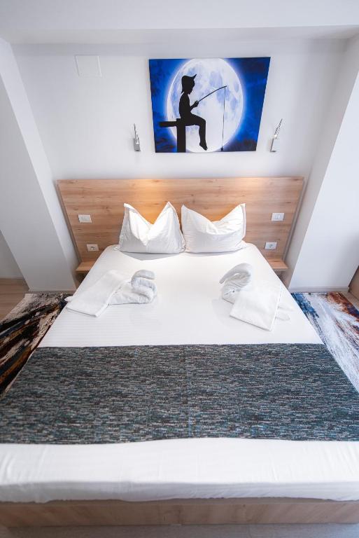 a bedroom with a large bed with a painting on the wall at Polu-X in Vama Veche