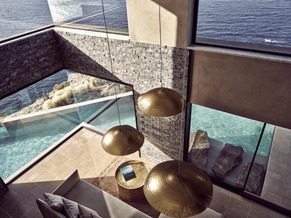 a room with a view of the water and two lights at Acro Suites - A Wellbeing Resort in Agia Pelagia