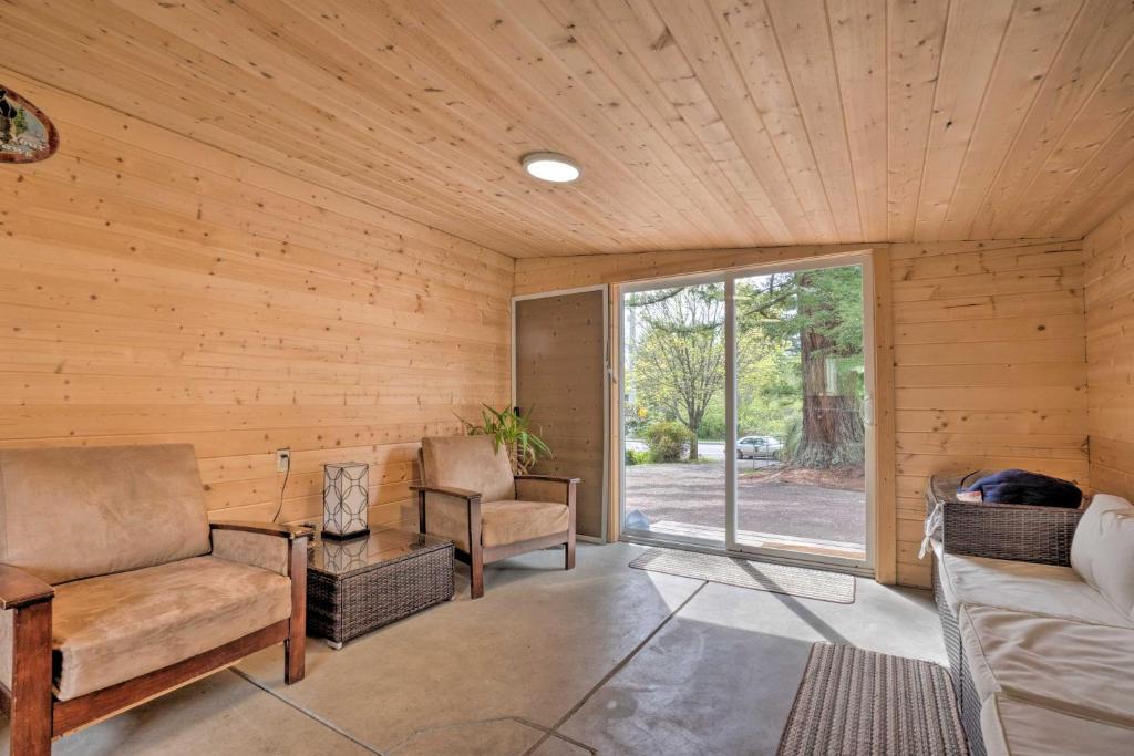 una sala de estar con paredes de madera y una gran ventana. en Brookings Home with Deck, half Mi to Harris Beach! en Brookings