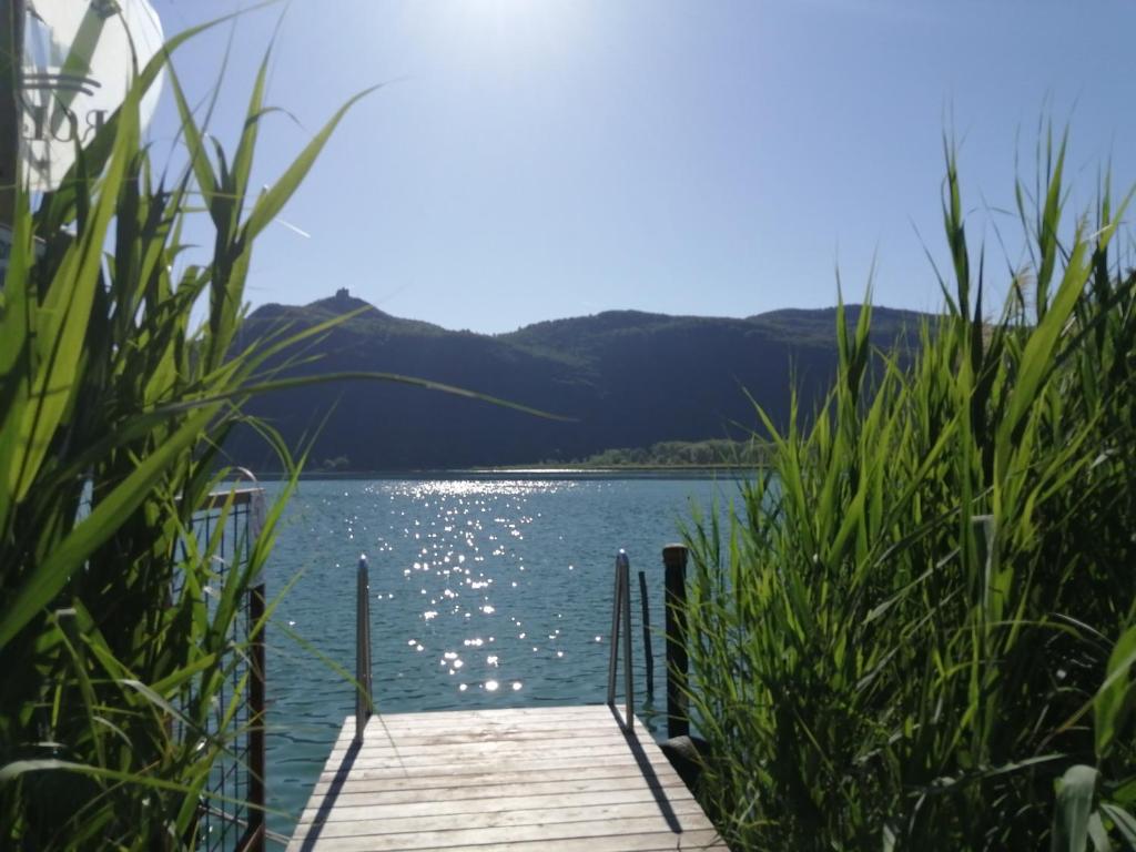 a dock on a lake with mountains in the background at Residence Roland in Caldaro