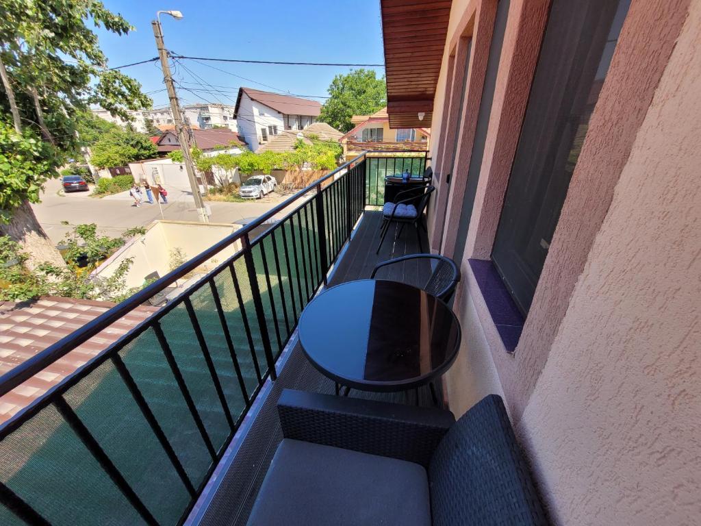 un balcón con 2 bancos y una mesa en un edificio en TEI House, en Năvodari
