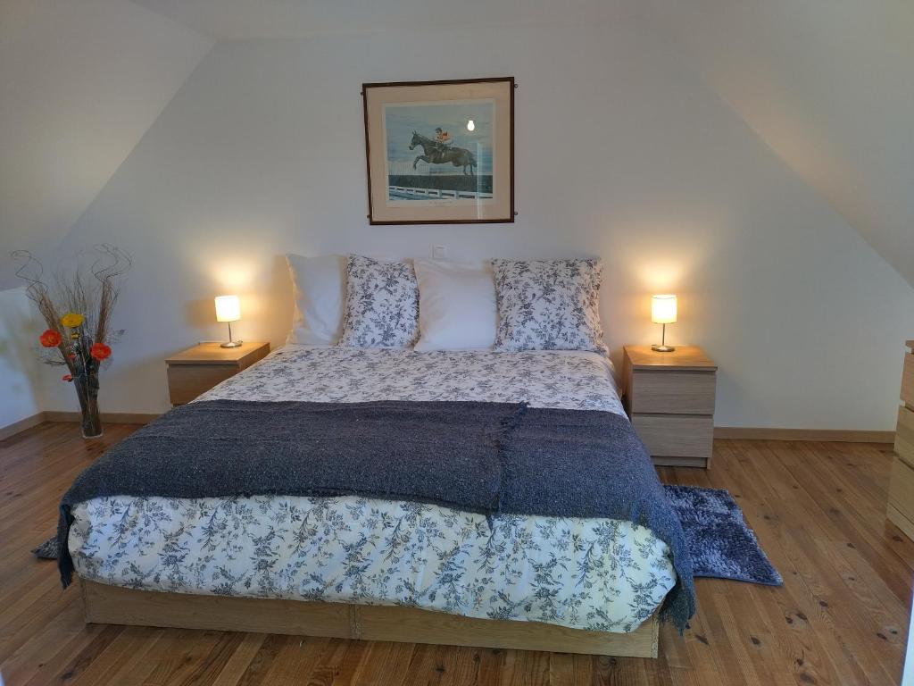 een slaapkamer met een groot bed met 2 lampen bij Verte Vallée in Callac