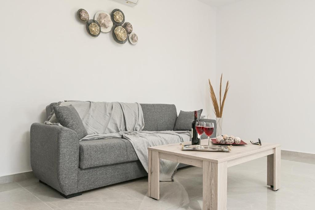 uma sala de estar com um sofá e uma mesa com um copo de vinho em Elaion Villa Naxos Town em Naxos Chora