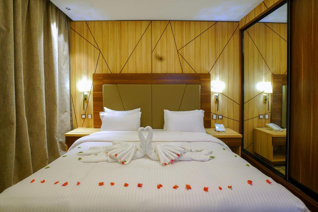 una camera da letto con un letto con rose rosse di Al Aseel Hotel a Doha