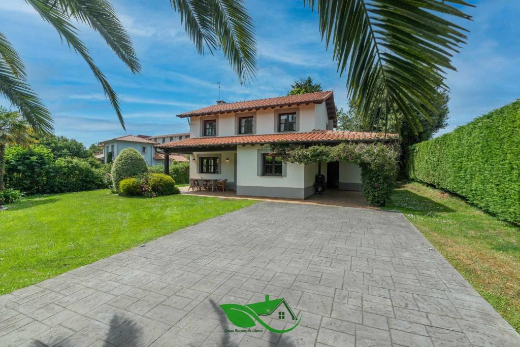 a house with a palm tree and a driveway at Vivienda Vacacional Villa Costa Cué in Cue