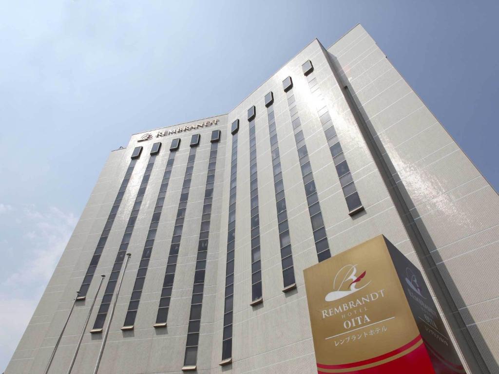 a tall building with a sign in front of it at Rembrandt Hotel Oita in Oita