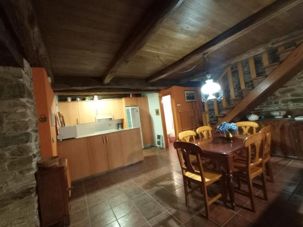 cocina y comedor con mesa y sillas en Casa de Abril 2, en San Cristóbal de Valdueza