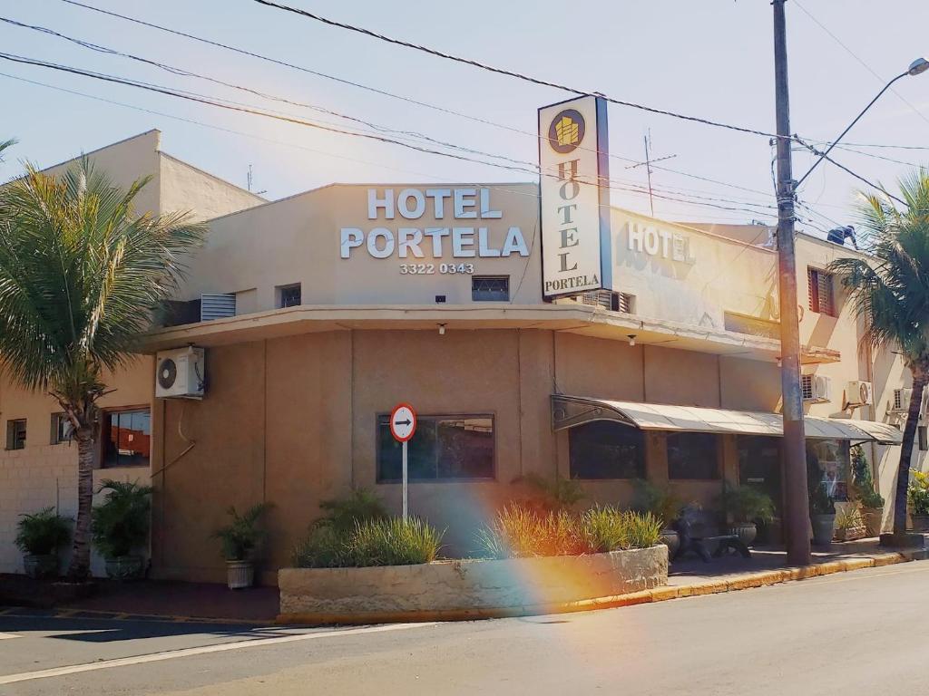 un hotel con un cartello sul lato di una strada di Hotel Portela I -Barretos a Barretos