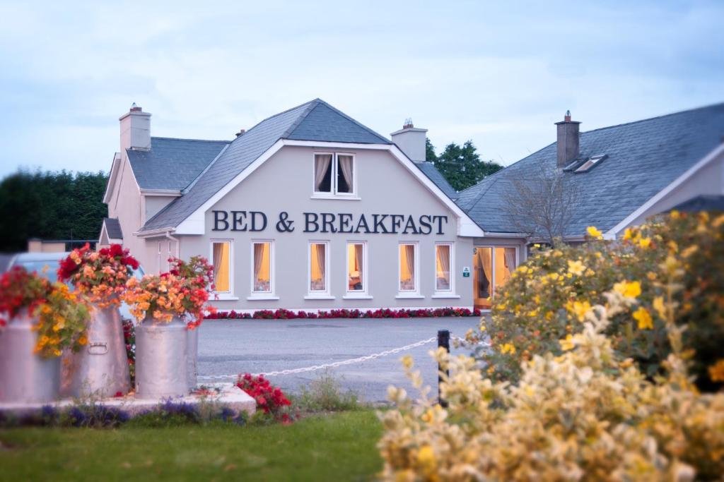 a white building with a bed and breakfast sign on it at Tower Lodge B&B in Mallow