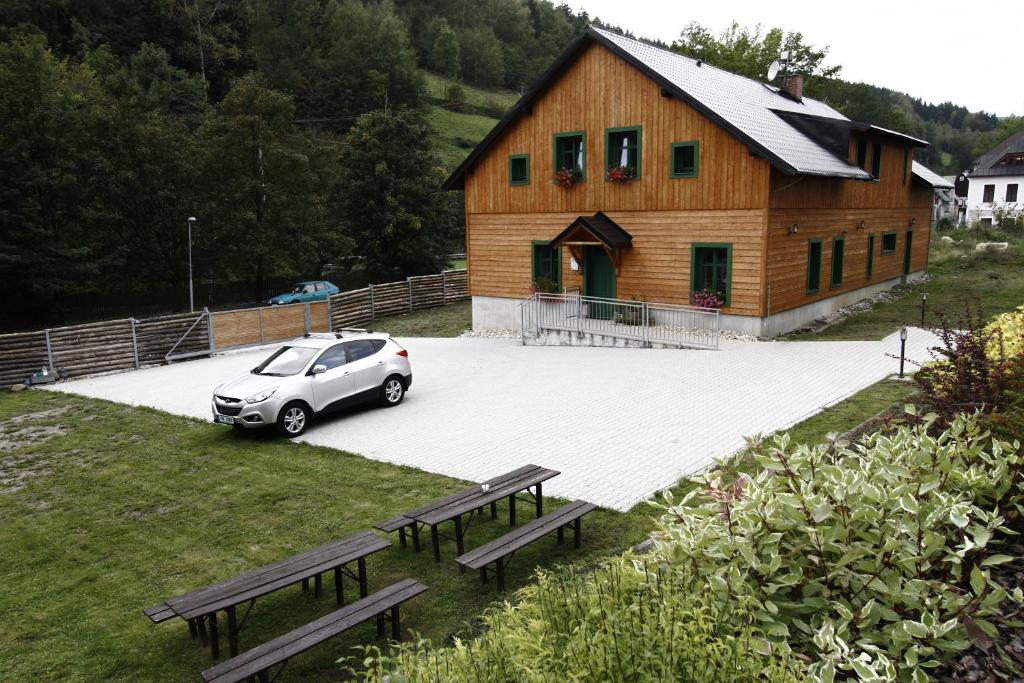 a small car parked in front of a wooden building at Janova Bouda in Dolni Dvur