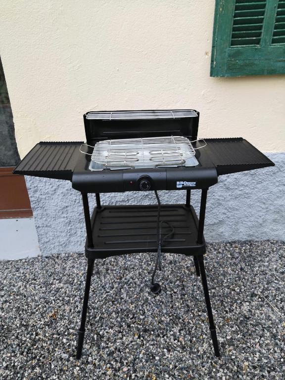 a black barbecue grill sitting in front of a building at Appartement entier T4 à Jausiers in Jausiers