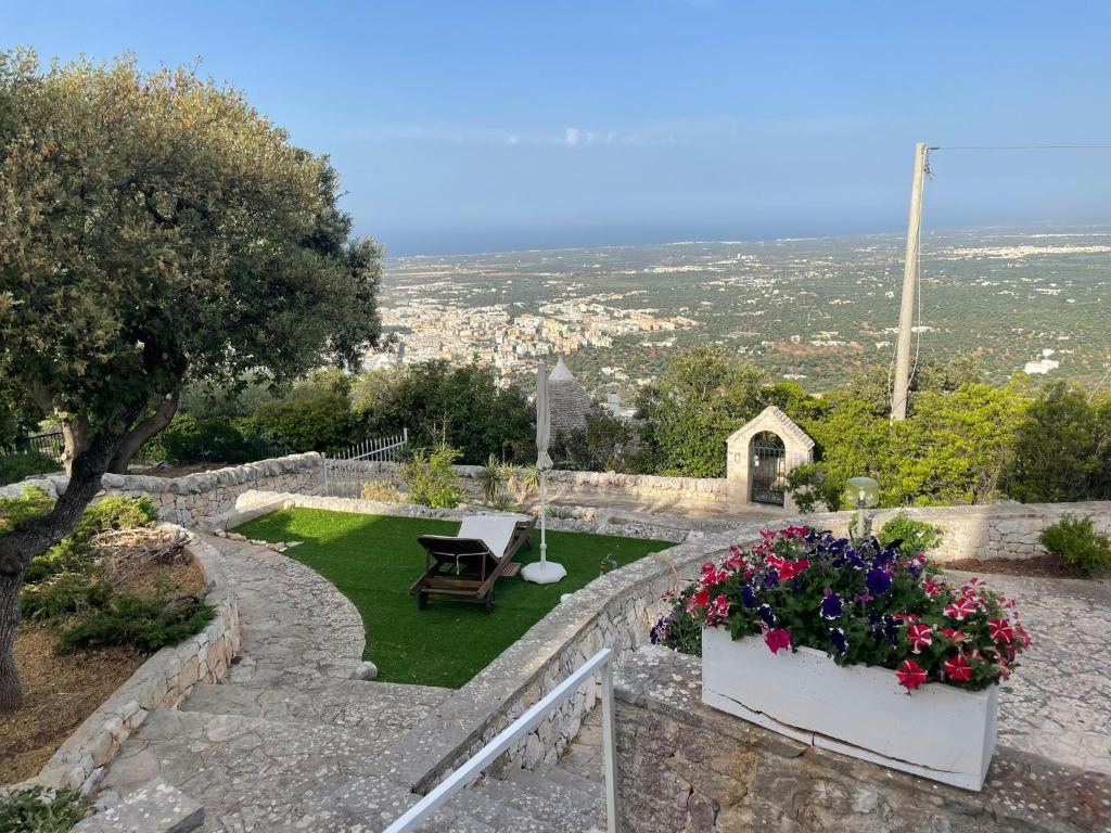 a garden with a bench and flowers on a hill at Domus Valentina in Selva di Fasano