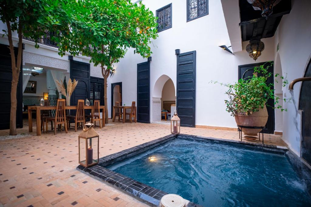 a swimming pool in the middle of a courtyard at Riad Ajmal in Marrakech