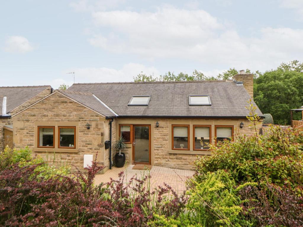 a stone house with windows and a roof at 2 Pheasant Lane in Deepcar
