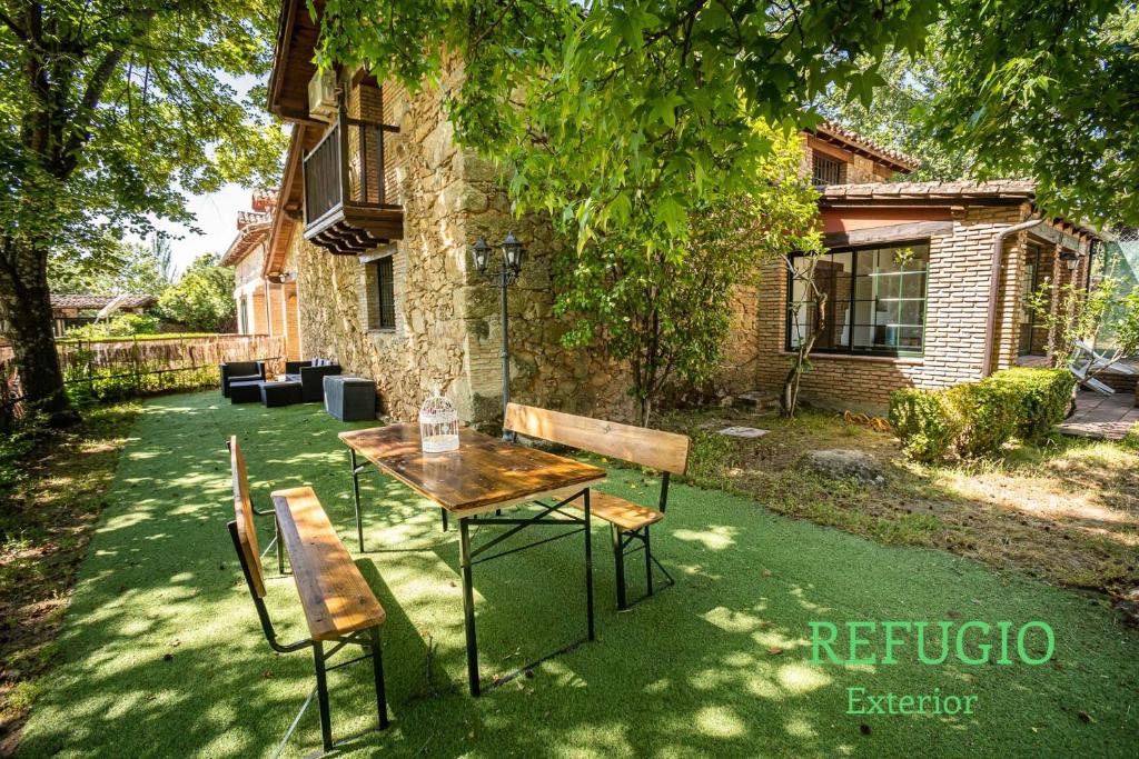 a table and chairs in front of a house at Casa rural Paraje de Yuste in Cuacos de Yuste