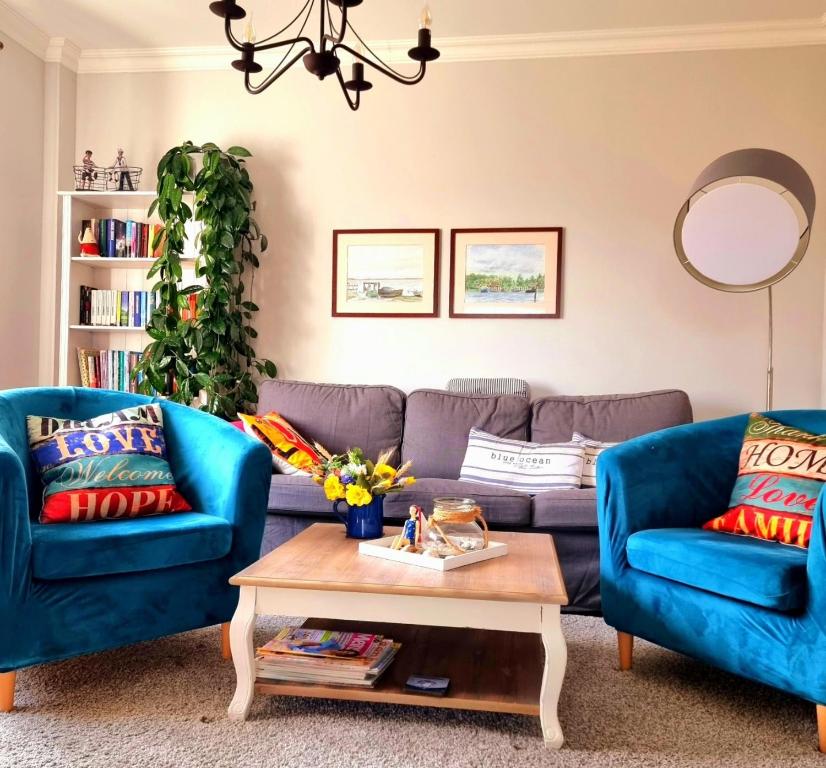 a living room with two blue couches and a coffee table at Haus Bärbel in Lietzow