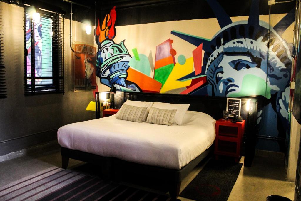 a bedroom with a bed with a painting on the wall at Hotel Sommelier LOFT in Santiago